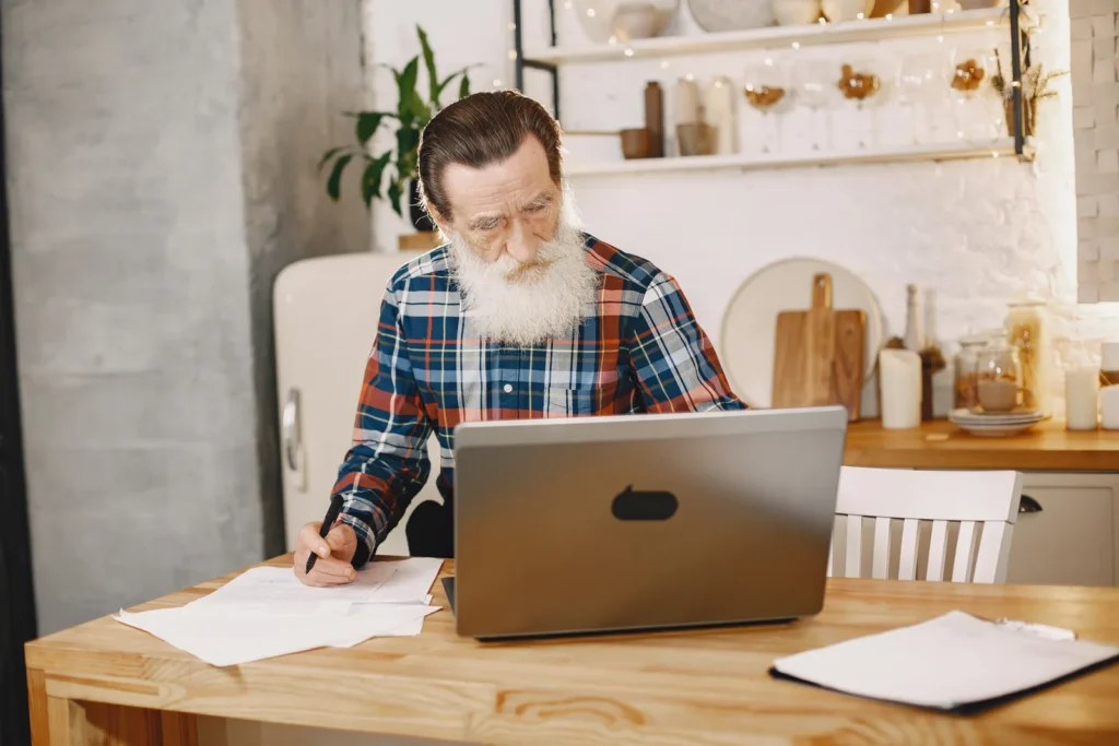 Pracovní stůl s notebookem a fakturami, průvodce pro nové OSVČ